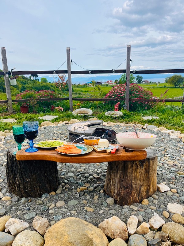 Fogón y mesa al aire libre en el jardín de Casa Maqui